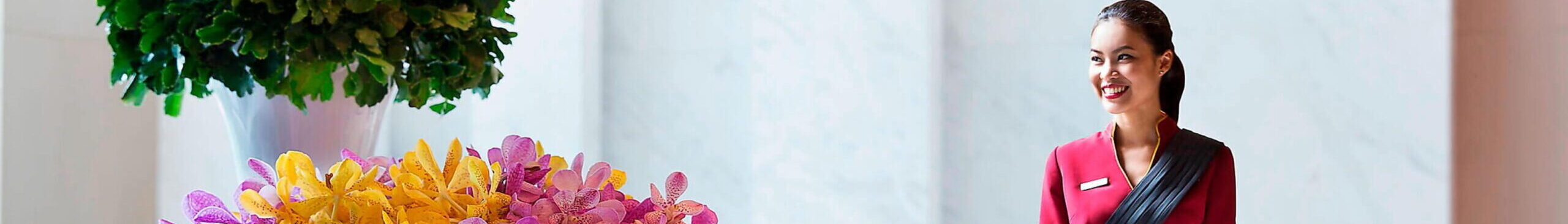 Woman smiling opposite flowers
